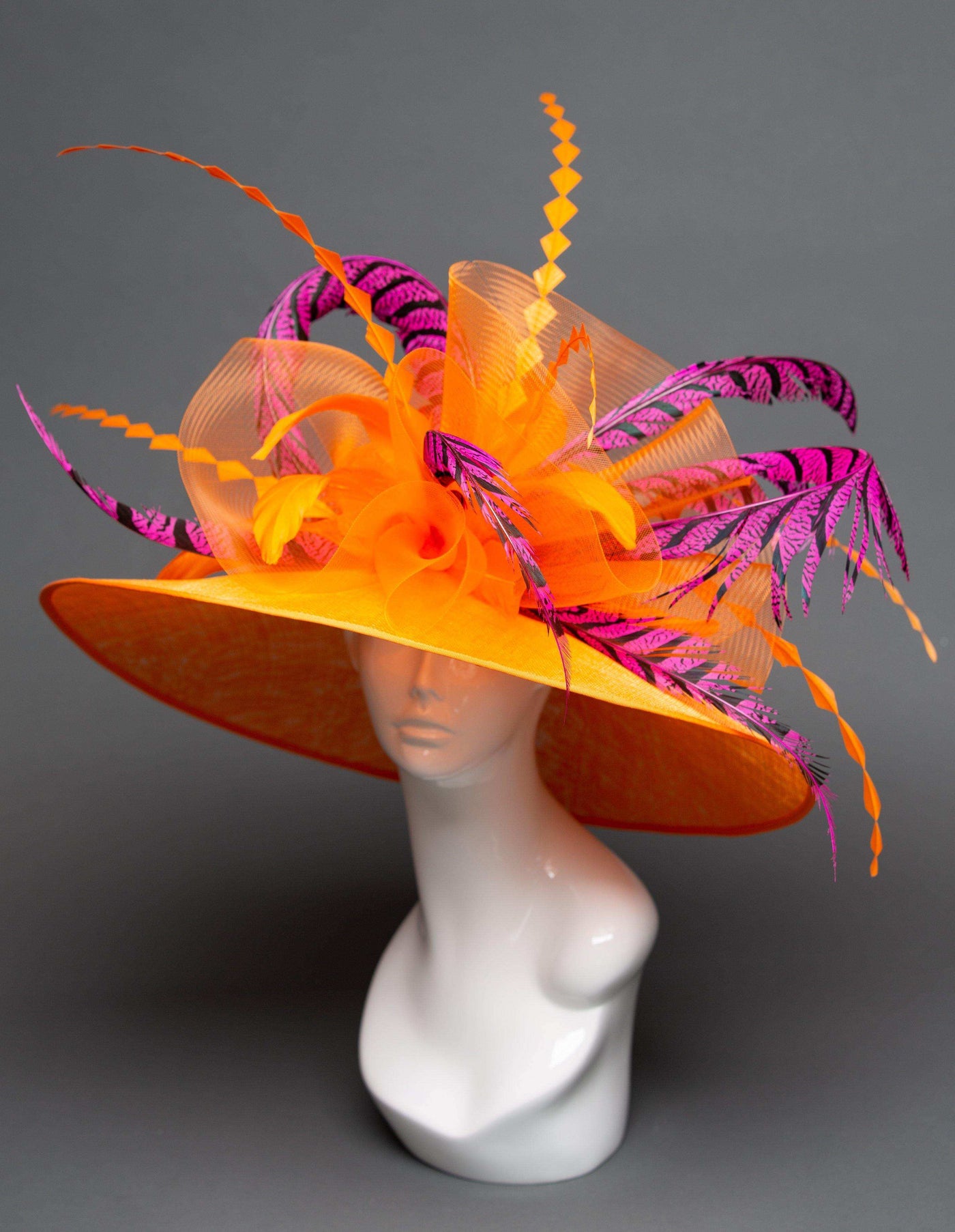 wide-brimmed orange hat with pink and orange pheasant feathers